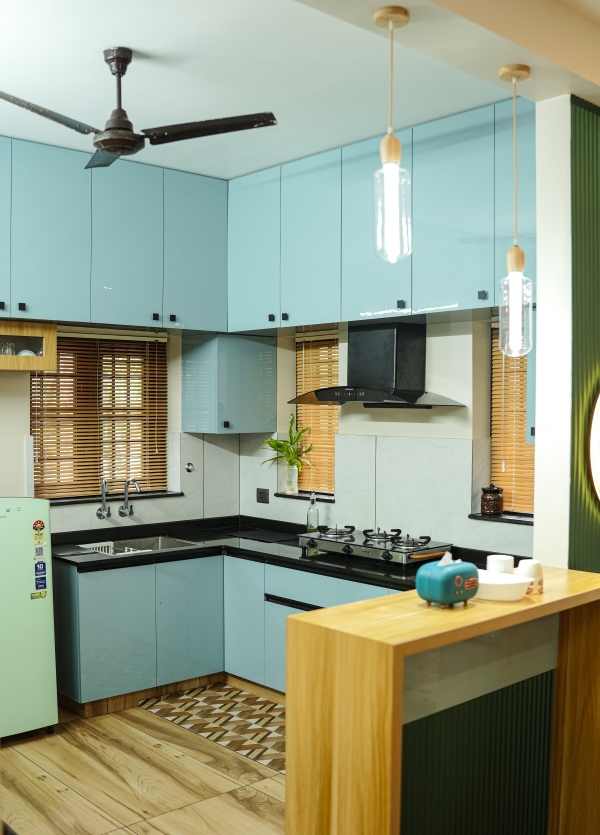 Modern open kitchen interior with wooden finish and bright lighting at Peyad, Thiruvananthapuram