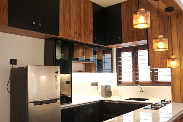 Custom modular kitchen setup with overhead cabinets at Pallichal, Thiruvananthapuram